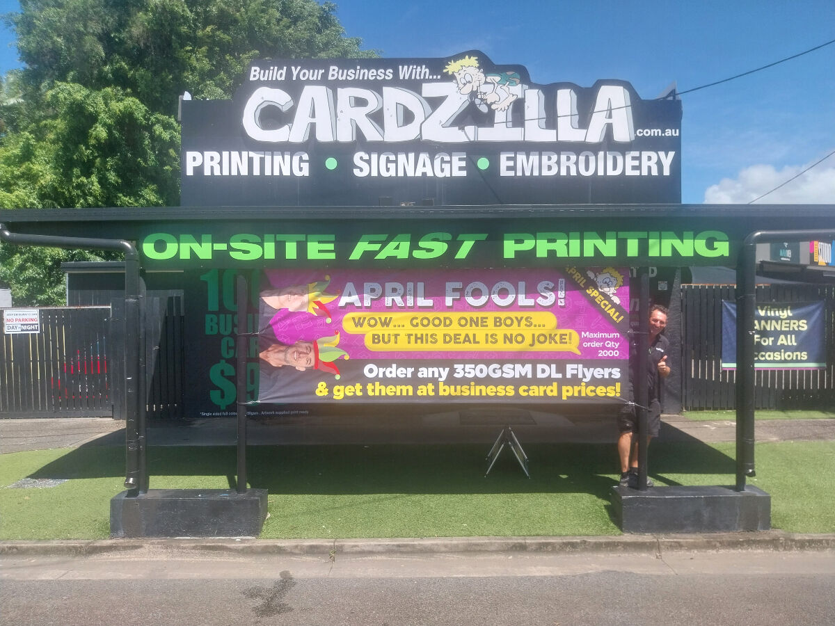 Cardzilla staff member out the front of store next to the DL flyer banner